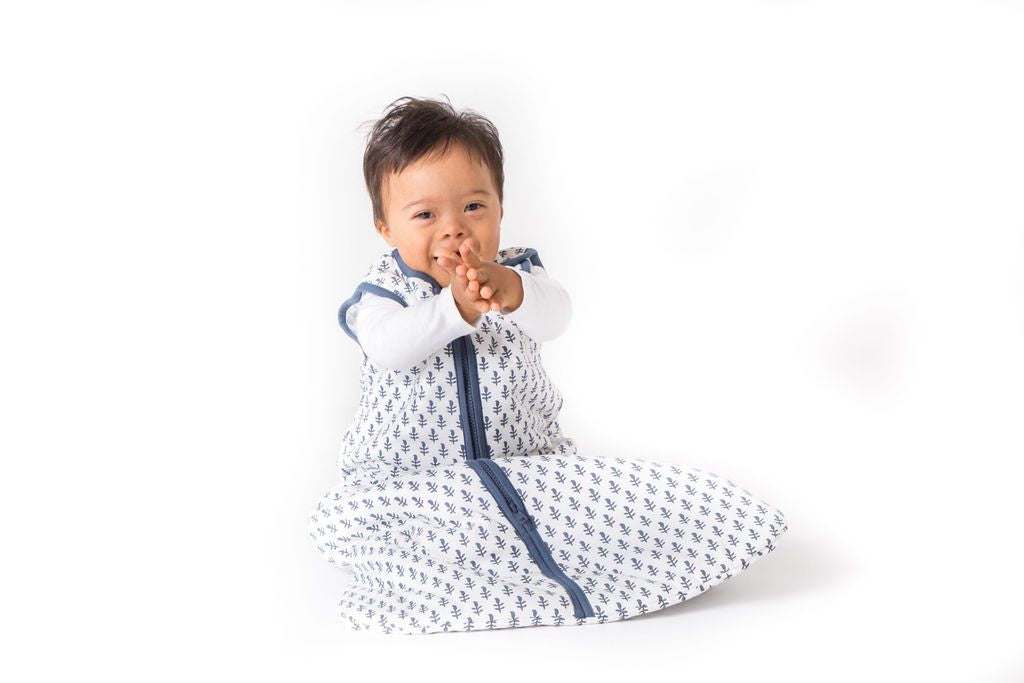 Baby wearing FORT Wearable Baby Sleep Bag made of lightweight organic cotton with blue leaf pattern
