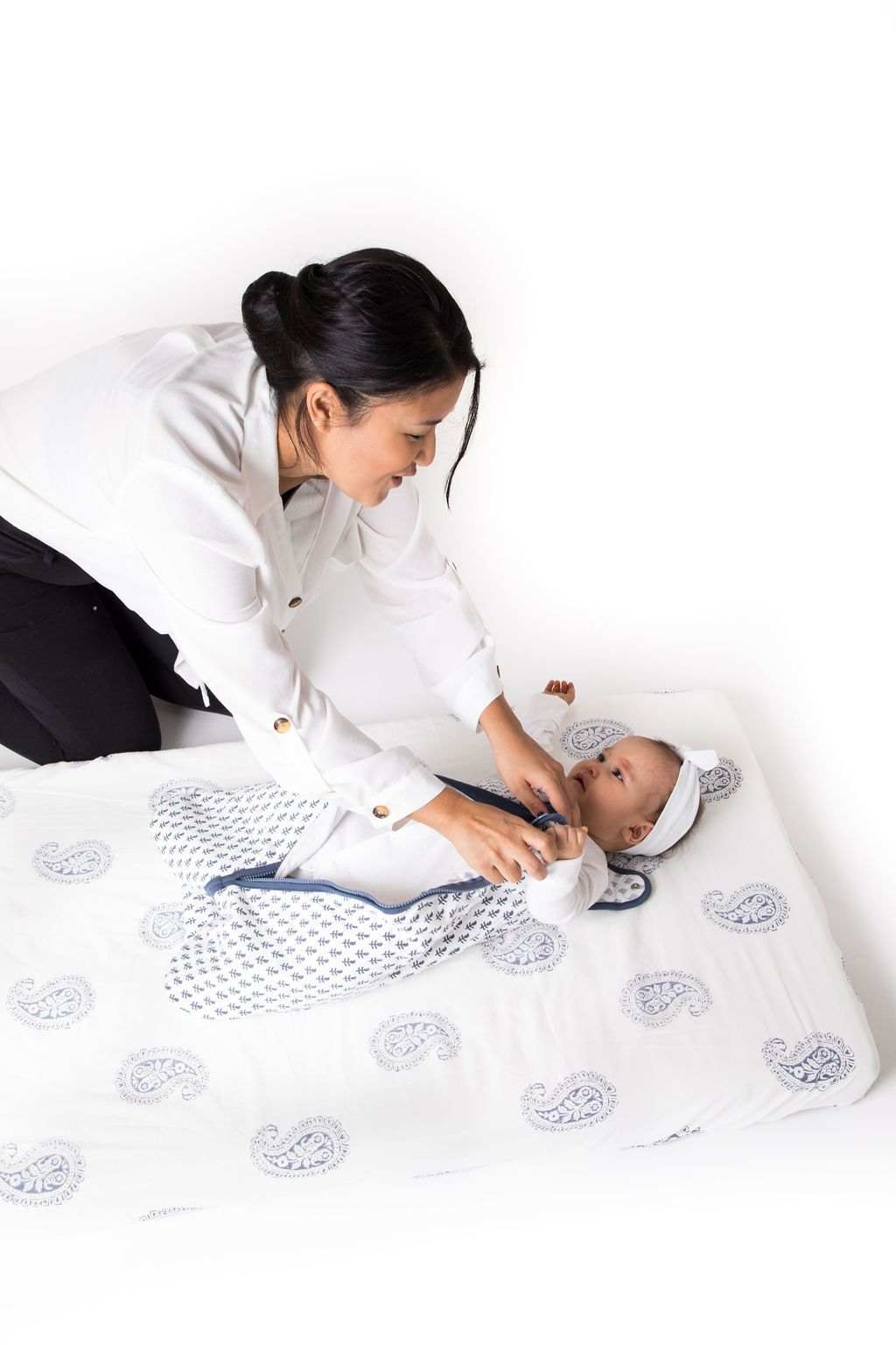 Mother dressing baby in FORT Wearable Baby Sleep Bag lightweight organic cotton blanket