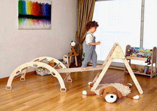 Child playing on Montessori climbing set with Pikler triangle and arch in a bright playroom